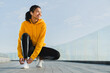 © InsideCreativeHouse - Full length portrait of a beautiful smiling young african girl tying shoelaces of her trainers after jogging
