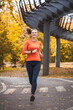 © Dmytro Titov - woman athlete on a morning jog in the autumn city park