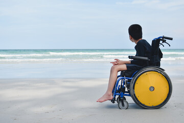 Wall Mural - sian special child on wheelchair is looking, playing and doing activity on the sea beach, Lifestyle of disability child, Life in the education age, Happy disabled kid in travel holidays concept.