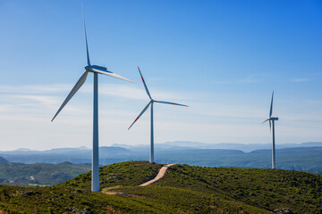 Wall Mural - wind turbines on a beautiful blue sky in a mountain wind farm in sardinia. renewable energy concept,