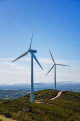 Wall Mural - wind turbines on a beautiful blue sky in a mountain wind farm in sardinia. renewable energy concept,