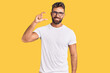 © Krakenimages.com - Young hispanic man wearing casual clothes and glasses smiling and confident gesturing with hand doing small size sign with fingers looking and the camera. measure concept.