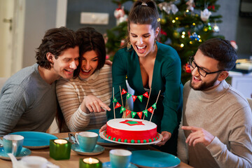 Wall Mural - Group of friends celebrating Christmas at home with fancy cake