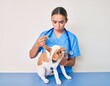 © Krakenimages.com - Young beautiful blonde veterinarian woman putting vaccine to puppy dog depressed and worry for distress, crying angry and afraid. sad expression.