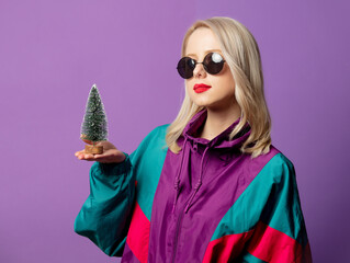 Canvas Print - Style blonde in 80s windbreaker and roud sunglasses with Christmas tree