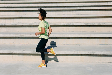 Wall Mural - Active young brunette running at modern stadium