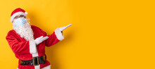 Santa Claus Isolated On Color Background Pointing To Space
