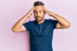 © Krakenimages.com - Handsome man with beard wearing casual clothes with hand on head, headache because stress. suffering migraine.