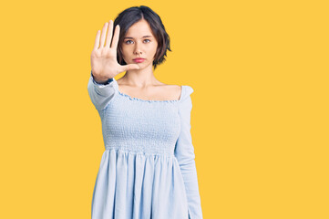 Young beautiful girl wearing casual clothes doing stop sing with palm of the hand. warning expression with negative and serious gesture on the face.