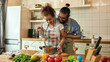 © Svitlana - Young couple preparing a meal together in the kitchen. Italian man, chef cook helping his girlfriend to use hand blender. Cooking at home, Italian cuisine