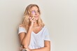 © Krakenimages.com - Young blonde girl wearing casual clothes and glasses thinking concentrated about doubt with finger on chin and looking up wondering