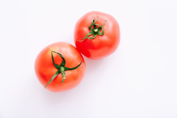 Two red tomatoes on a white background with copy space, top view