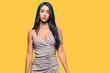 © Krakenimages.com - Beautiful hispanic woman wearing summer dress with serious expression on face. simple and natural looking at the camera.