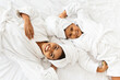 © Prostock-studio - Happy African Mother And Daughter In Bathrobes And Towels Lying On Bed