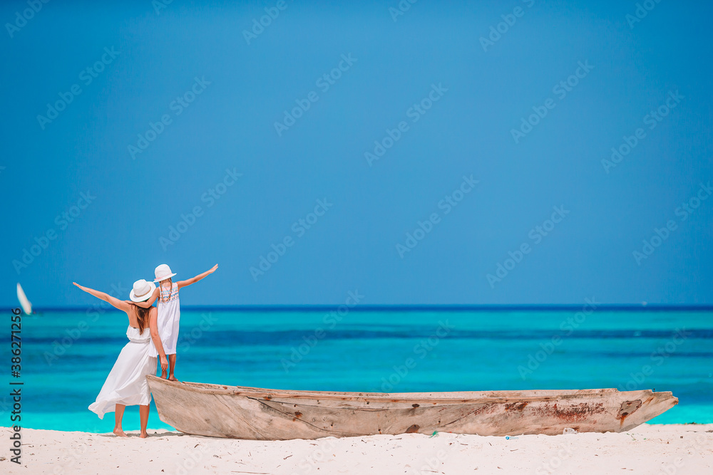 Beautiful mother and daughter at Caribbean beach enjoying summer vacation. - obrazy, fototapety, plakaty 