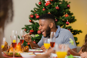 Wall Mural - Summer Christmas dinner in Brazil. Real Brazilian family having fun at the Latin American Christmas party. latin man having dinner