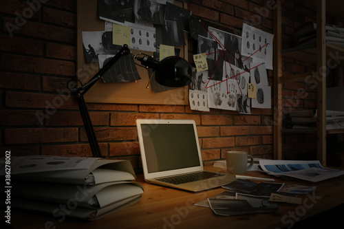 Workplace with laptop and detective board in office