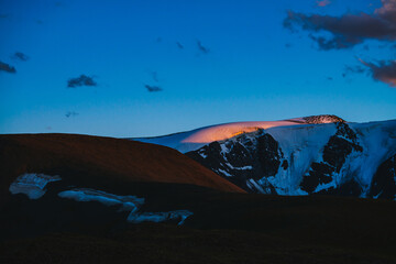 Wall Mural - atmospheric dawn landscape with silhouettes of snowy mountains with glaciers. colorful mountain scen