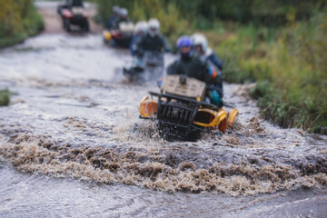 Wall Mural - Group of riders riding atv vehicle on off road track, process of driving ATV vehicle, all terrain quad bike vehicle, during offroad competition, crossing a puddle of mud