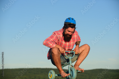 Fotografía Funny man on a childrens bike. Nerdy cyclist riding.