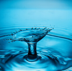 Water drop falling down. Abstract blue background