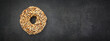 © flukesamed - top view of chocolate donut with peanut topping on dark gray, grey, black tone texture background with copy space for text