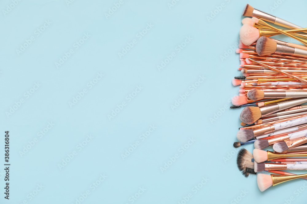 Set of makeup brushes on color background