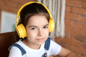 Cute little girl listening to music at home