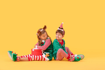 Poster - Cute little elves with Christmas gift on color background