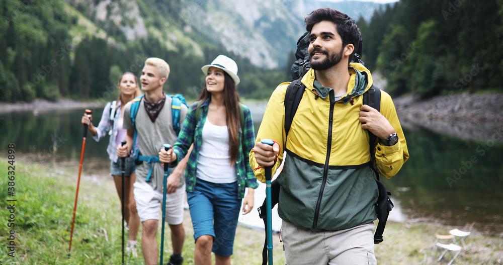 Group of fit healthy friends trekking in the mountains - obrazy, fototapety, plakaty 