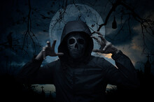 Human Skull In Jacket Standing Over Cross, Church, Crow, Bat, Birds, Dead Tree, Full Moon And Sunset Sky, Halloween Mystery Concept