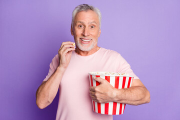 Canvas Print - Photo of funny grandfather cuddle paper box eat popcorn toothy smile wear pink t-shirt isolated purple color background