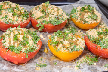 Provencal tomatoes - preparation of a dish, halves of tomatoes sprinkled with breadcrumbs, herbs and onions on a baking sheet