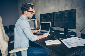 Profile side view portrait of his he nice skilled expert geek guy specialist solving problem remote 24 on 7 tech support dev ops at modern industrial interior style concrete wall work place station
