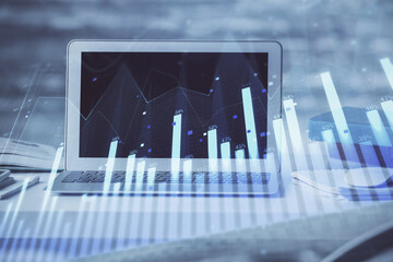 Stock market chart hologram drawn on personal computer background. Double exposure. Concept of investment.