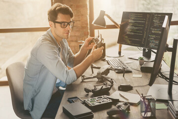 Profile side view portrait of his he nice attractive confident focused guy tech specialist inventing repairing air drone home-based studio at modern brick loft interior style work place station