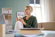 © Halfpoint - Portrait of business woman indoors in office sitting at desk, holding cup of tea.
