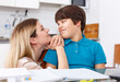 © JackF - Portrait of smiling mother helping son with homework and having good time in kitchen