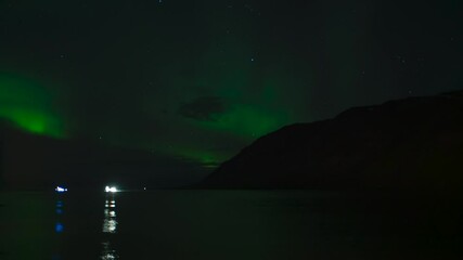 Wall Mural - fishing boat heads out to sea under aurora borealis in northern iceland