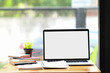 © Prathankarnpap - Workspace with blank screen desktop laptop, plant and notebooks on wooden desk.