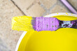 Used flat decorator brush covered with dry violet and wet yellow color