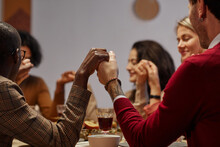 Multi-ethnic Group Of People Holding Hands In Prayer At Thanksgiving Dinner With Friends And Family, Focus On Foreground, Copy Space