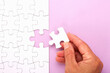© rgvc - Hand placing white jigsaw puzzle piece. Horizontal composition with copy space.