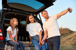© anatoliy_gleb - Father is taking selfie of his beautiful family sitting in the car trunk and having pizza and wine, family look white t-shirts and blue jeans