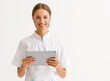 © JenkoAtaman - friendly doctor nurse with tablet wireless computer smiles in isolated against   white background.