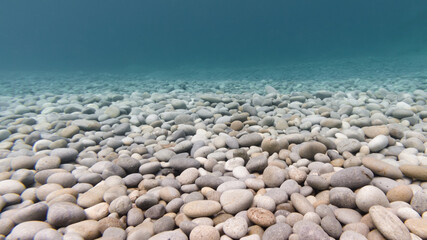 Underwater photo of pebbles on the beach in crystal clear water in the philippines