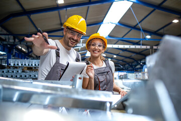 Factory workers controlling quality of manufactured products together.