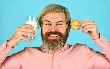 Wall Mural - Bearded man drink milk with cookies. Leave it for Santa. Breakfast or lunch. Milk and sweet cookies. Happy hipster eat cookie dessert. Delicious treats. Homemade is best. Recipe for baking cookies