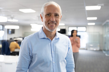 Portrait of senior businessman smiling at modern office