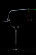Red wine is poured into a broken glass silhouette on Black Background. High quality photo. 